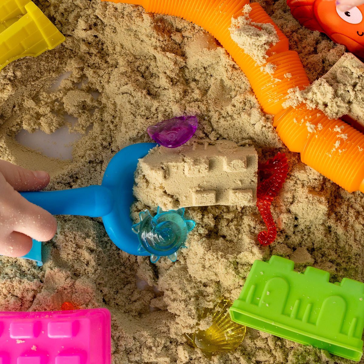 Child digging and exploring mouldable sand in the Beach Sensory Bin