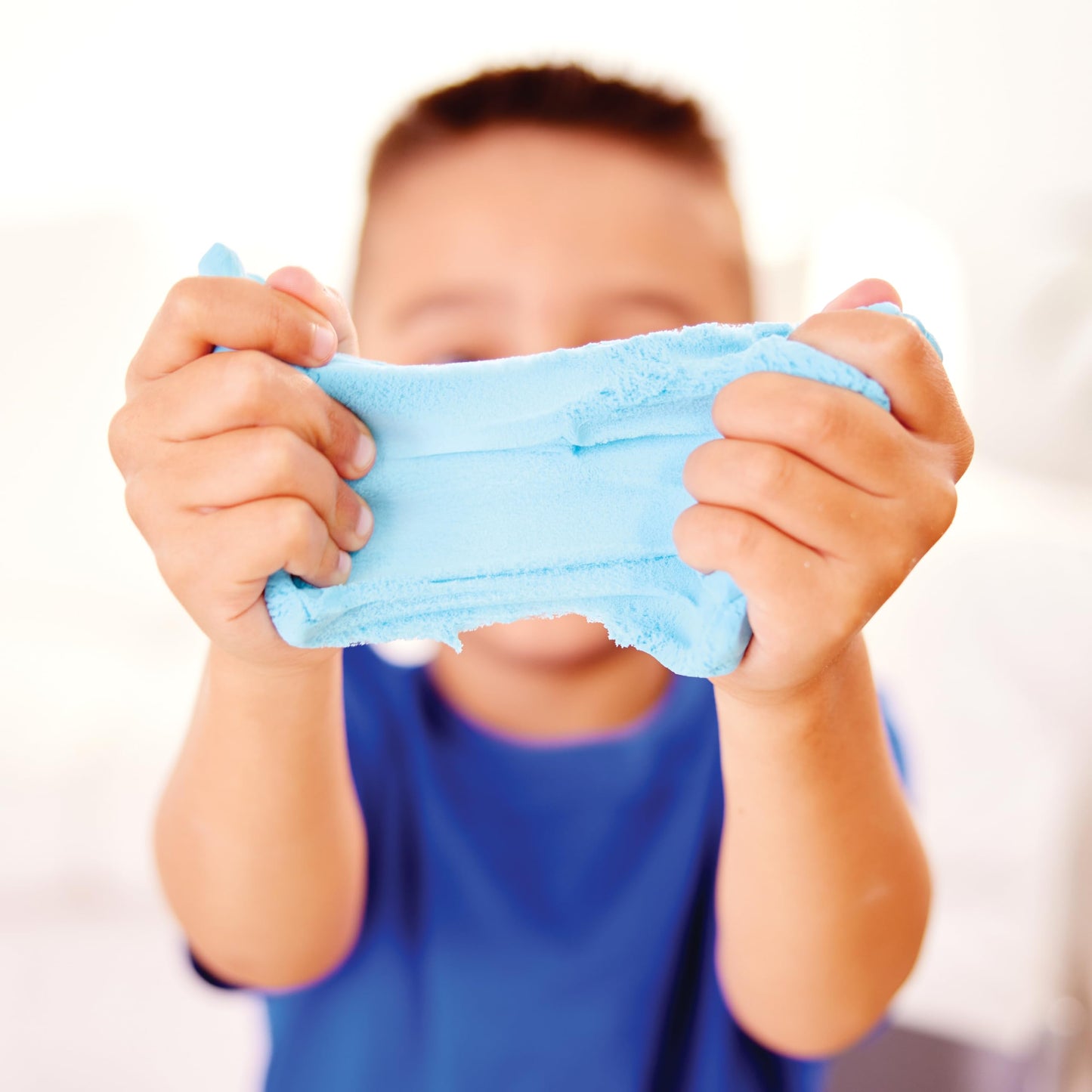 Child stretching sensory cloud clay during hands-on play
