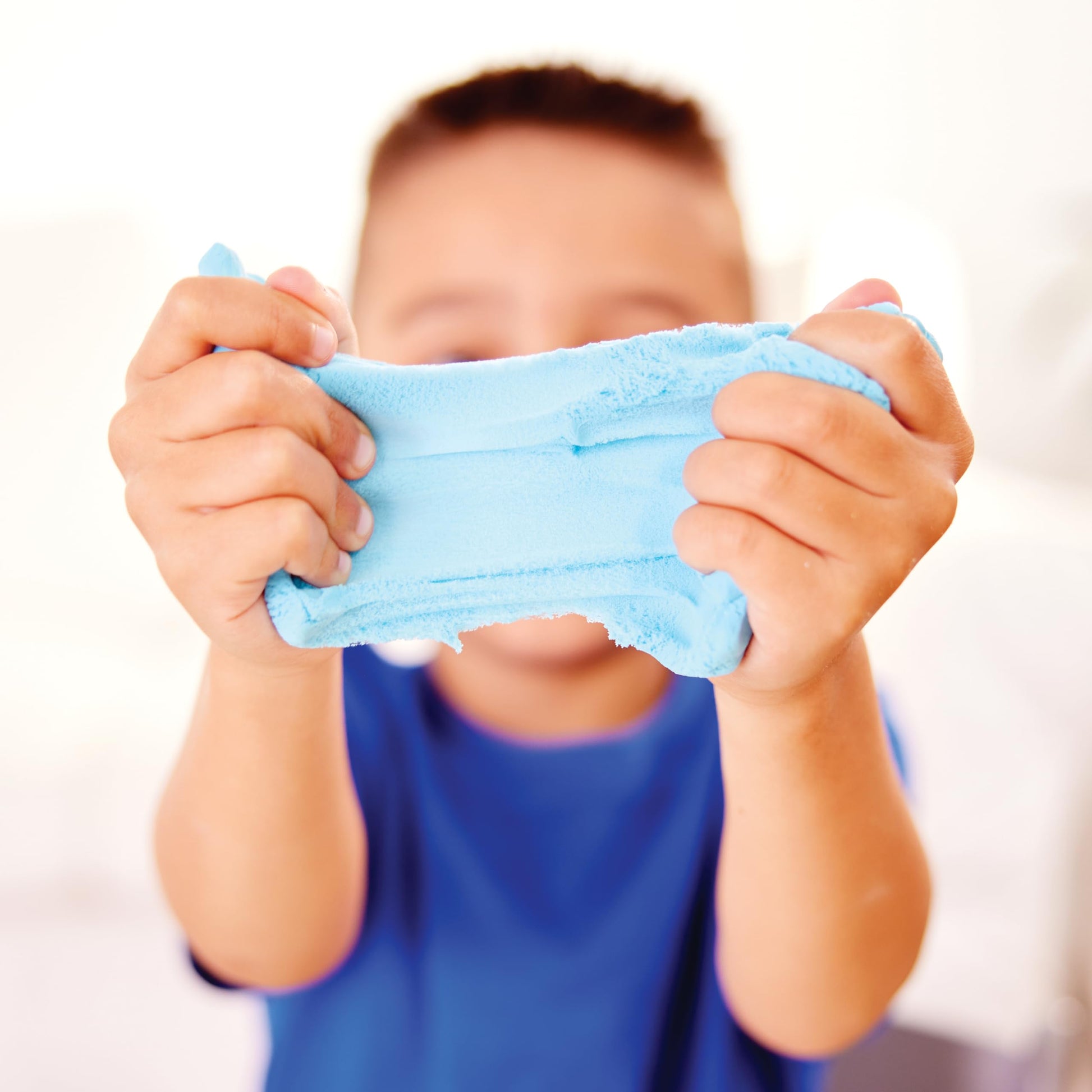 Child stretching sensory cloud clay during hands-on play