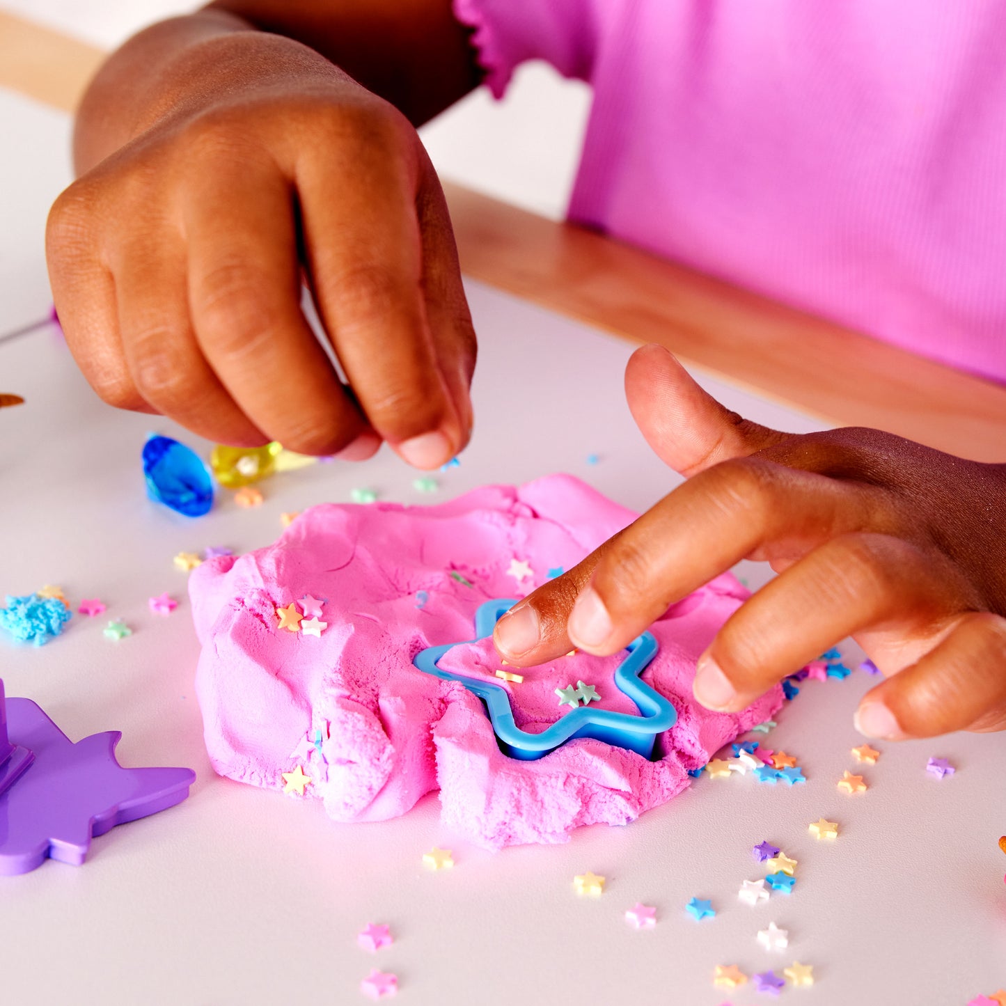 Child creating a unicorn scene with colourful sensory cloud clay